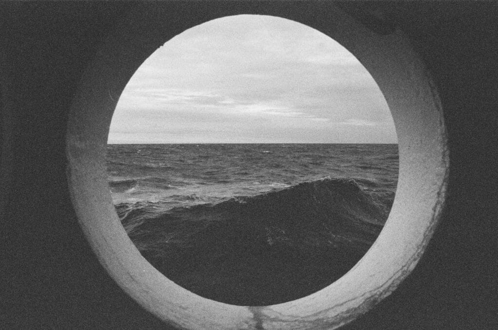 A look through the porthole of a cruise ship underway.